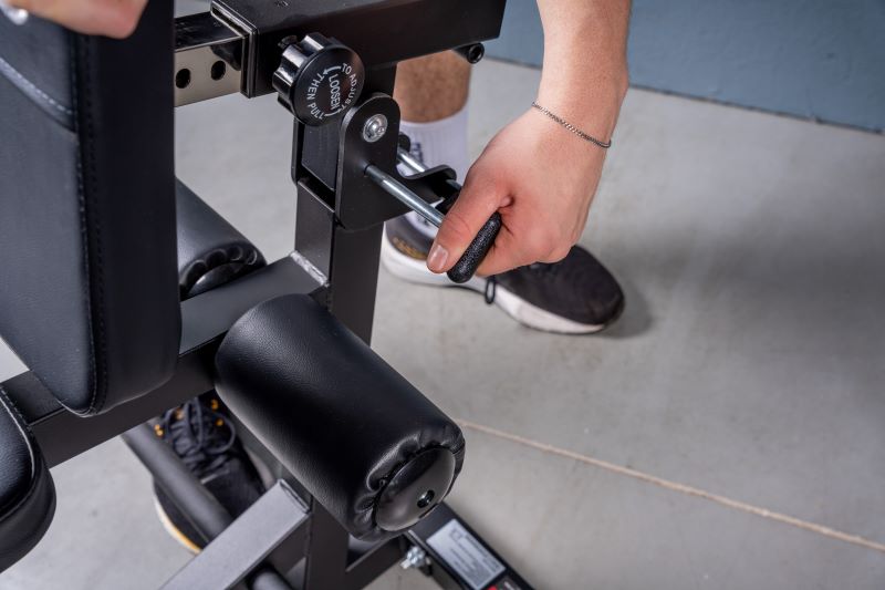Nahaufnahme des 4-in-1 Multitrainers von Taurus, der von einem Mann verstellt wird.